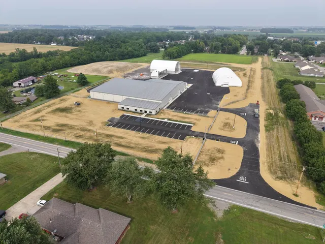 Aerial view of a commercial development with graded and seeded grounds around new buildings and paving