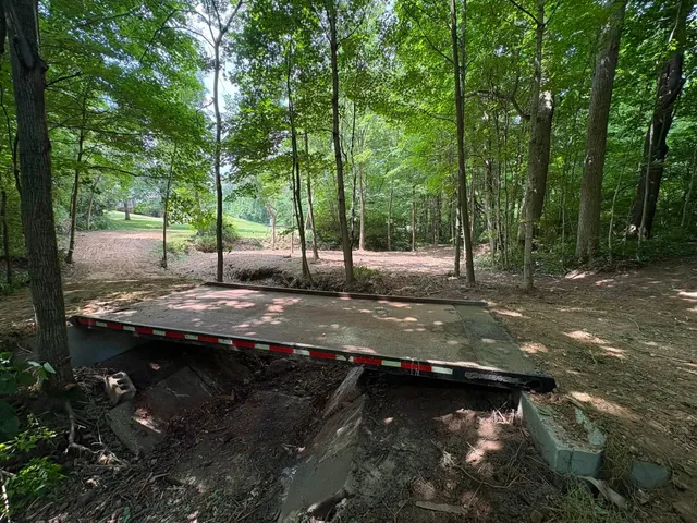 New crossing built over culvert pipe in a wooded creek bed